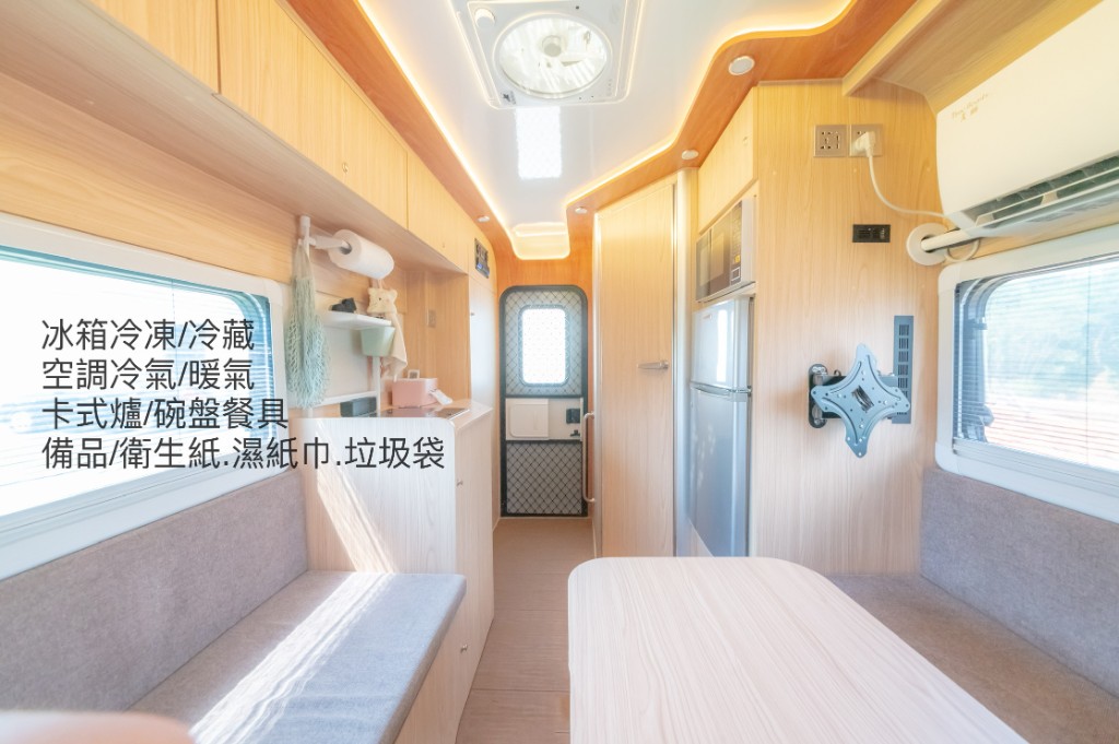 台北露營車出租車內實景：冷暖變頻空調、雙門冰箱、流理台與餐桌走道，展示衛浴以外廚飲與舒適溫控設備齊全