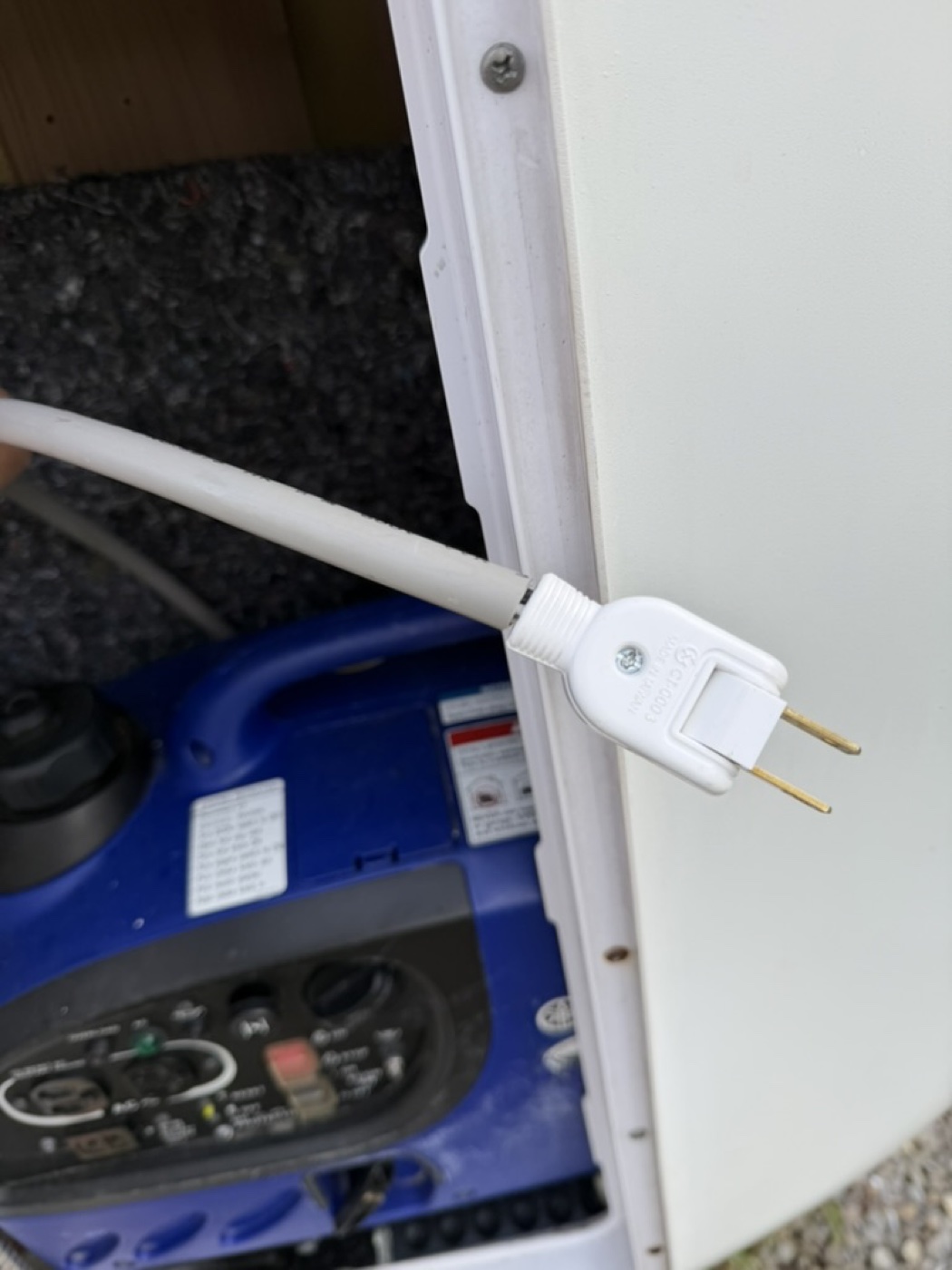 台北露營車出租｜露營車左後艙內白色兩孔充電插頭特寫，可搭配延長線接露營區插座，或直接插在內建／外置發電機 AC 插座為露營車電池充電