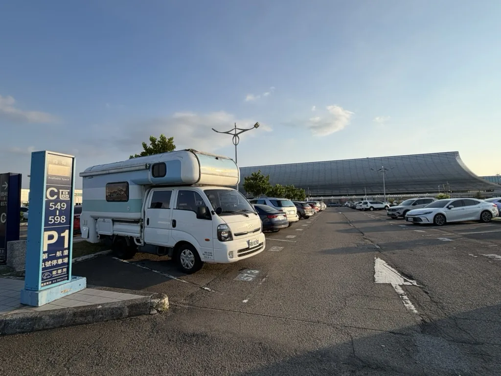 藍白色台灣露營車停在桃園國際機場第一航廈停車場，準備迎接從澳洲抵達的英國旅人展開環島公路旅行