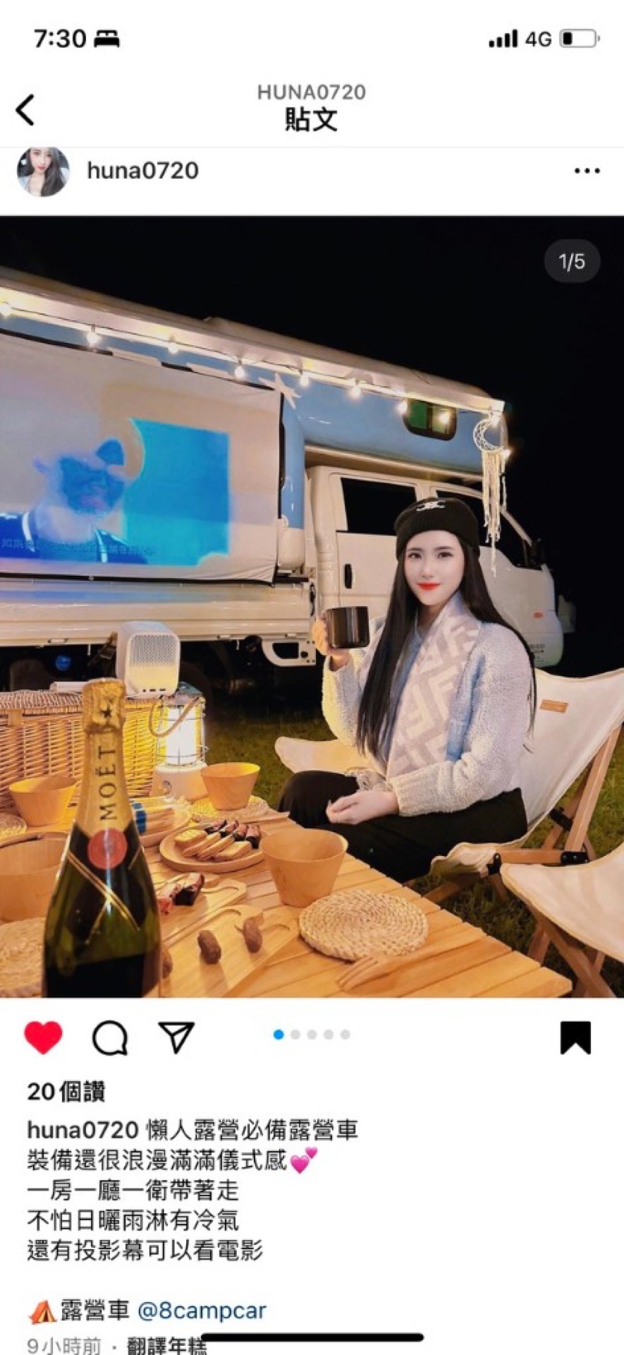 Kenting night beside campervan, traveler in folding chair with cup smiling, movie projected on van side, champagne snacks warm string lights—lazy glamping romantic movie night