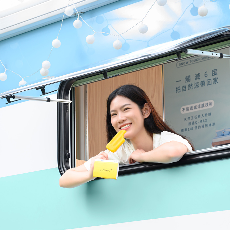 模特自露營車側窗探出，手持黃色冰棒與飲品微笑，車頂白色燈串，車內可見 SNOW TOUCH 一觸減六度等文宣海報