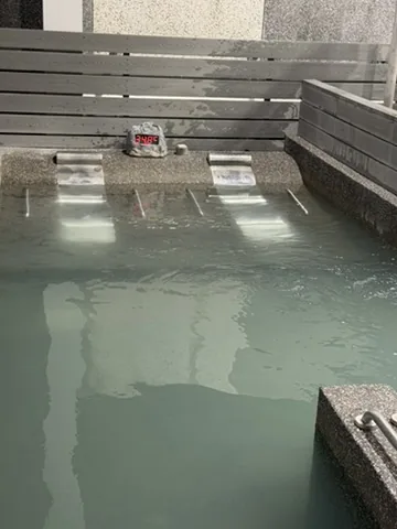 帶有關子嶺泥漿溫泉色澤的水療池，池邊水柱持續注入溫泉水
